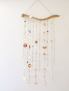 a wind chime hanging on the wall with seashells