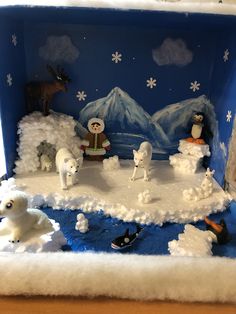 there is a fake snow scene with polar bears and other animals in the background,