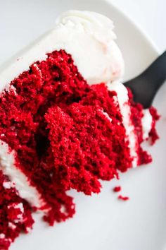 a slice of red velvet cake with white frosting