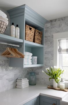 a kitchen with gray cabinets and white counter tops