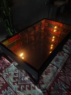 candles are lit in the middle of a glass table