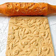 a wooden rolling pin next to a cookie sheet