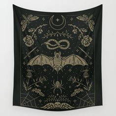 a bat hanging on the wall in front of a black background with gold and white designs