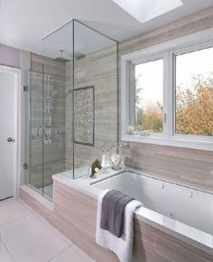 a bath room with a tub a sink and a window on the side of it