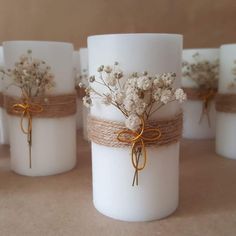 white candles with twine and flowers tied to them