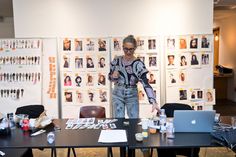 a woman standing in front of a table with two laptops