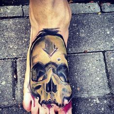 a person with a skull tattoo on their foot