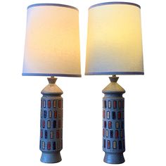 two lamps are sitting next to each other on a white background, one is blue and the other is red