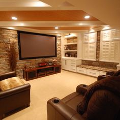 a living room filled with furniture and a flat screen tv mounted to the side of a wall