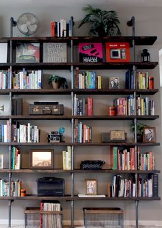 a bookshelf filled with lots of books in a living room