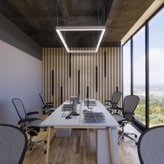 an empty conference room with chairs and desks in front of large windows overlooking the city