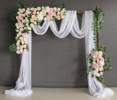 a wedding arch decorated with flowers and greenery