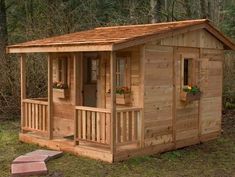 a small wooden cabin in the woods with flowers on the window sill and steps leading up to it