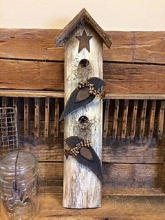 a wooden birdhouse with three birds hanging from it's side