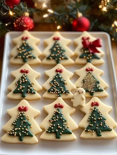 decorated cookies on a white plate with christmas trees