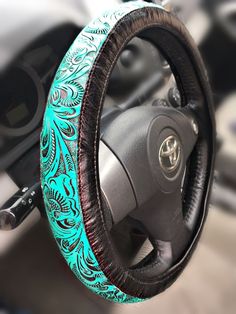 the steering wheel cover is decorated with blue and black designs on it's sides