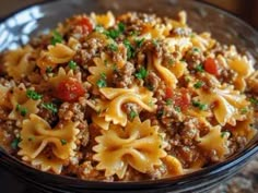 a bowl filled with pasta and meat on top of a table