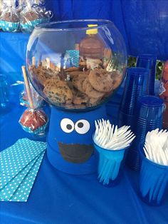 there is a blue table with cookies and cupcakes in the shape of a cookie monster