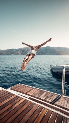 a man dives into the water from a boat