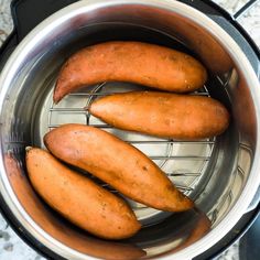 three sweet potatoes sitting in an air fryer