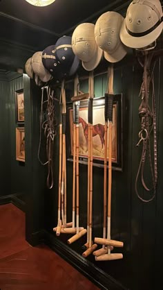 several hats are hanging on the wall with baseball bats