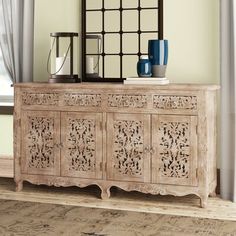 This classic sideboard brings a natural look to your dining room or living area. Showcasing openwork botanical designs on the cabinet doors and a carved apron along the bottom of the frame, it adds an eye-catching, boho vibe to your space. Made from kiln-dried mango wood, the sideboard has a natural wood grain color variation and wood scoring that enhances its charm. The four drawers and cabinets with timeless white ring pulls offer ample storage for your tableware, dishes, and other essentials. Furniture Anchors, Mango Wood Sideboard, Rustic Sideboard, Farmhouse Sideboard, Upholstered Panels, Wood Sideboard, Traditional Furniture, Southern Home, Solid Mango Wood