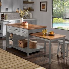 a kitchen island with two stools in front of it and a table on the other side