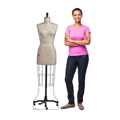 a woman standing next to a mannequin with her arms crossed and looking at the camera