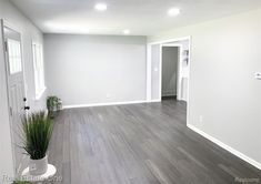 an empty room with white walls and wood floors