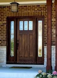 the front door is made of wood and has two sidelights on either side of it