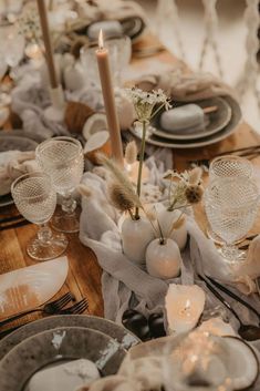 the table is set with dishes and candles