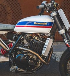 a white and blue motorcycle parked next to a building