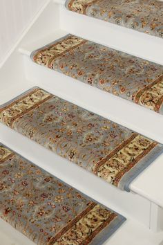 three rugs are on the stairs in front of a white wall and carpeted floor