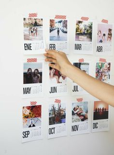 a person holding up a calendar with photos on it