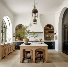 a large kitchen with an island in the middle and two stools at the end