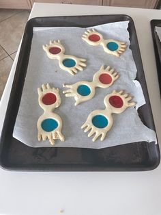 four decorated cookies sitting on top of a cookie sheet in the shape of handprints