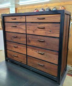 a large wooden dresser sitting on top of a metal floor in a room filled with furniture