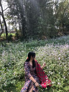 a woman sitting in the middle of a field