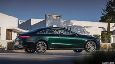 a green car parked in front of a house