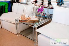 a living room filled with white furniture and lots of books on top of a table