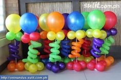 a bunch of balloons that are in front of a door with some string on them