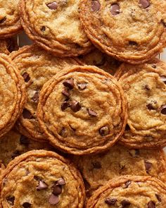 chocolate chip cookies are piled on top of each other in the middle of a pile