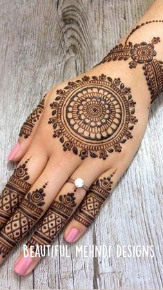 a woman's hand with henna tattoos on it