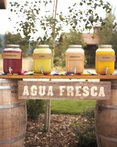 there is a sign that says agua fresca on the side of some barrels