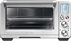 a toaster oven with the door open and an electronic timer on it's side