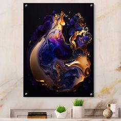 an abstract painting with gold and purple colors on a black background in a living room