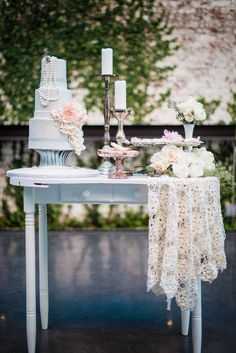 a table with a wedding cake and two candles on it