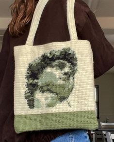 a woman carrying a bag with a portrait of a man on it