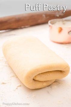 an uncooked pastry roll sitting on top of a counter next to a knife