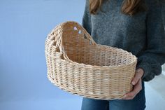 a woman holding a wicker basket in her hands